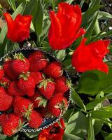 Delicious Red Strawberry with Freshness and Juicy Appeal Delicious, juicy red strawberries among fresh green leaves and a flowering plant. photo