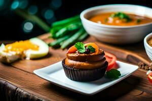 a cupcake with vegetables and a bowl of soup. AI-Generated photo