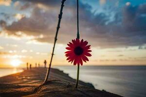 a red flower is hanging from a pole in front of the ocean. AI-Generated photo