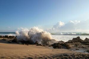 Waves breaking on rocky beach photo