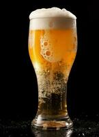 A glass of cold fresh beer with cap of foam. Splash of foam with tasty american beer. Beer day concept by AI Generated photo