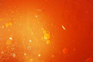 Gold Oil bubbles close up. circles of orange water macro. abstract shiny yellow background photo