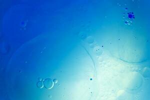 Oil bubbles close up. circles of water macro. abstract light blue background photo