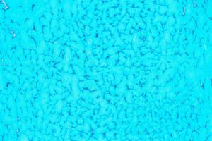 Old blue paint peeling from metal or concrete wall texture background. photo