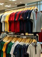 fila de de moda polo camisetas para hombre en de madera percha o estante en un ropa boutique Al por menor tienda concepto por ai generado foto