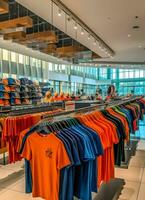 Row of fashionable polo t-shirts for man on wooden hanger or rack in a clothing boutique retail shop concept by AI Generated photo