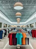 Row of fashionable polo t-shirts for man on wooden hanger or rack in a clothing boutique retail shop concept by AI Generated photo