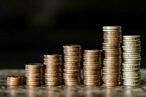 Stacks of savings coin arranged in ascending order on wooden working table or high coin towers representing the richness concept by AI Generated photo