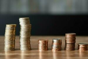 Stacks of savings coin arranged in ascending order on wooden working table or high coin towers representing the richness concept by AI Generated photo