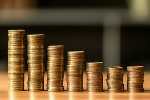 Stacks of savings coin arranged in ascending order on wooden working table or high coin towers representing the richness concept by AI Generated photo