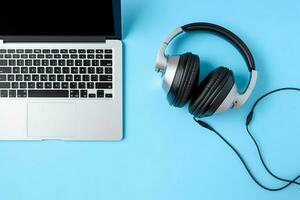 Music or podcast background with electronic devices, headphones, coffee and laptop on office desk concept by AI Generated photo