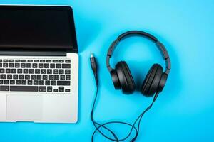 Music or podcast background with electronic devices, headphones, coffee and laptop on office desk concept by AI Generated photo