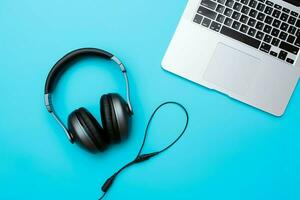 Music or podcast background with electronic devices, headphones, coffee and laptop on office desk concept by AI Generated photo