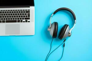 Music or podcast background with electronic devices, headphones, coffee and laptop on office desk concept by AI Generated photo