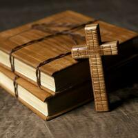 Close up of a holy bible and christian cross on wooden table. Happy good friday or religion concept by AI Generated photo