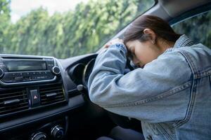 Sad Asian woman in the car, she is involved in a car accident photo