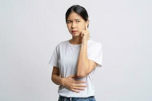 Asian woman has an earache. She uses her hand to touch her ear. Otitis media or tinnitus concept. photo