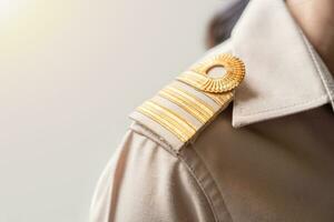 Photo of a brown uniform with a gold stripe on the shoulder, Thai civil servant uniform.
