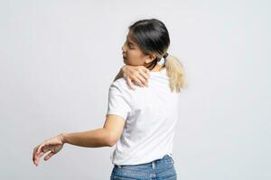 Asian woman wearing white t-shirt with shoulder and back pain standing isolated on white background. photo