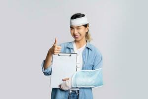 Asian woman with broken arm holding accident insurance policy papers photo