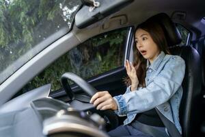 Asian woman shocked and shouting while driving on the road She was involved in a car accident. photo