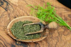 Dill Anethum graveolens on olive wood photo