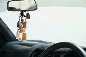 Closeup Buddha amulets hang in front console of the car. Concept, faith and belief for Buddhist for holy and luck. Prevention from accident. Culture of faith. photo