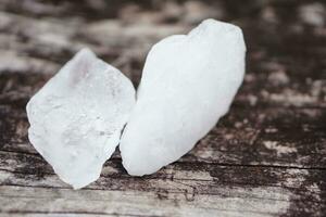 blanco alumbre piedras en de madera piso antecedentes. tailandés utilizar eso a obtener eliminar de cuerpo olor y columpio el sucio agua a hacer agua claro. útil para belleza y spa tratamiento. utilizar a tratar agrietado tacones foto