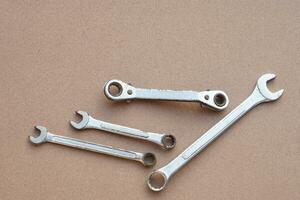 Set of metal wrenches isolated on brown background. Concept, handyman, mechanic tools. Spanners. Equipment for fixing or repairing, renovation in daily life. photo