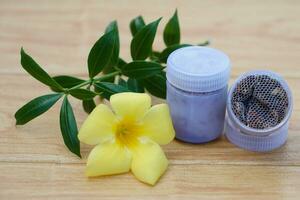 Bottles of homemade Thai herbal powder for smell to relieve dizzy symptoms, decorate with yellow flower.Concept, Thai local wisdom to use dry fragrant herbs to make inhaler photo