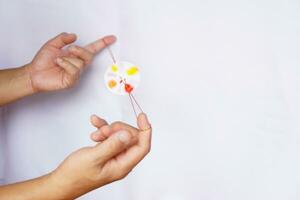 manos son jugando el bricolaje hilado rueda juguete, hecho desde cuerda y circulo papel. concepto, retro juguete cuales aplicar con Ciencias conocimiento. potencial energía en el cuerda cuando relajarse crea cinético. foto