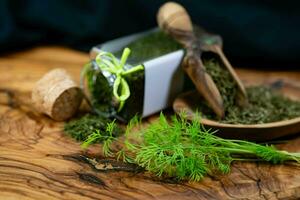 Dill Anethum graveolens on olive wood photo