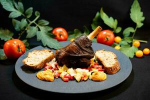 Grilled lamb shank from the charcoal grill with a fresh salad photo