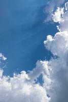 un azul cielo de mullido nubes y luz de sol foto