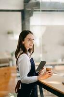 Startup successful small business owner sme woman stand with tablet  in cafe restaurant. photo