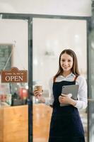 Startup successful small business owner sme woman stand with tablet  in cafe restaurant. photo