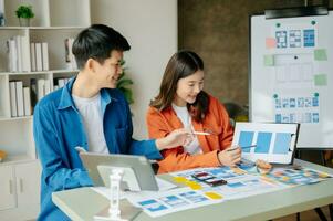 UX developer and ui designer brainstorming about mobile app interface wireframe design with customer breif and color code at office. photo