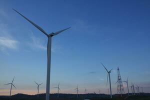 Wind turbines at sunset with a beautiful sky in the background. The concept of renewable energy. photo