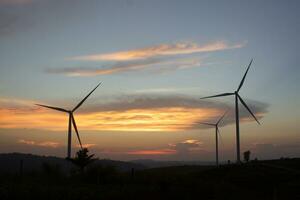 Wind turbines at sunset with a beautiful sky in the background. The concept of renewable energy. photo