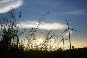 Wind turbines at sunset with a beautiful sky in the background. The concept of renewable energy. photo