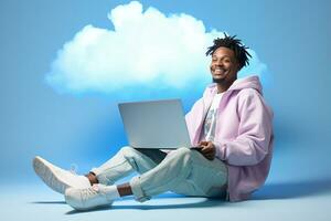 a man is sitting with a laptop in front of clouds photo