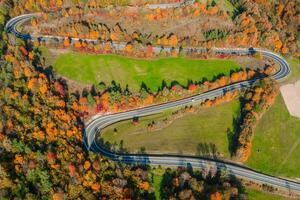 hermosa aéreo paisaje de montaña bosque la carretera. aéreo ver de curvilíneo la carretera en hermosa otoño bosque foto