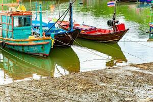 con bandera tailandesa pescar barcos línea el río en el bullicioso puerto, capturar el esencia de el vibrante pescar industria en tailandia foto