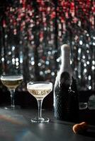 imagen de celebracion. el champaña botella salpicaduras siguiente a cuales son dos lentes de champán el antecedentes de bokeh con colores rojo y plata. oscuro gris Roca mesa. foto