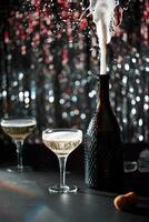 Image of celebration. The champaign bottle splashing next to which are two glasses of champaign. The background of bokeh with colors red and silver. Dark grey stone table. photo