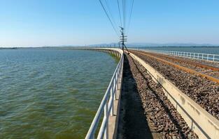 el curvo hormigón puente de el ferrocarril línea a lo largo el grande reservorio. foto