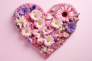 Field flowers in the shape of a heart on a pink background. photo