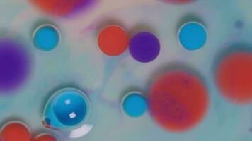 Top view of colored acrylic paint bubbles moving on milk, oil, liquid macro background. video