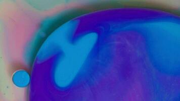 Top view of colored acrylic paint bubbles moving on milk, oil, liquid macro background. video