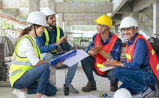 happy engineering team applaud during sitting on floor and meeting at the new building under construction, successful engineers teamwork working on site photo